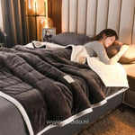 CozyFleece donkergrijs pluche woldeken op bed met slapende persoon
