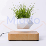 Witte zwevende pot met groen gras op lichtbruine basis.