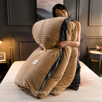 Vrouw met opgevouwen beige dekbedovertrek met dekbed erin op een bed
