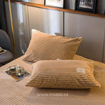 2 kussens met beige kussenslopen op een bed