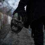 Hand houdt schedelmasker in donkere omgeving