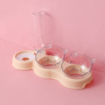 Lege beige voederbak en waterfles op roze achtergrond.