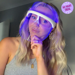 Vrouw draagt blauw LED-lichttherapie masker voor huidbehandeling.