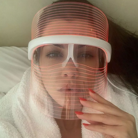 Vrouw draagt LumiGlow LED masker met rood licht voor huidverjonging.