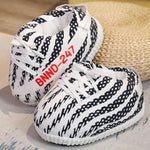 wit met zwarte strepen slofsneakers en witte veters, rieten ondergrond.